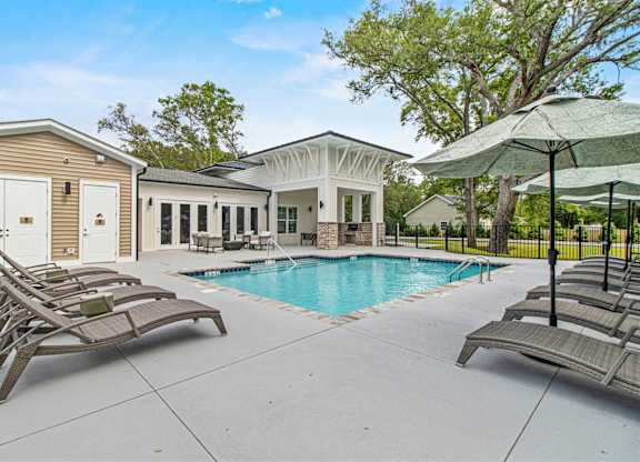 A pool area with sun loungers and a gazebo.