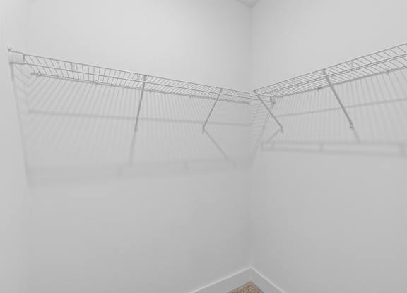 A white wire shelf in a white room.