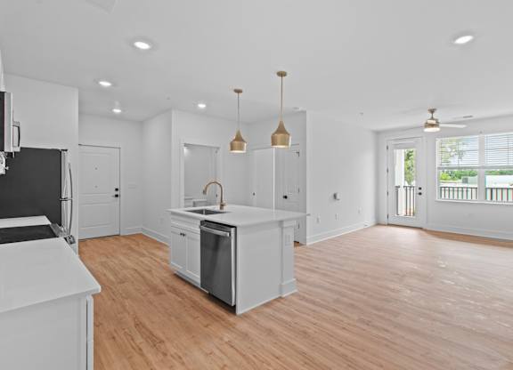 A kitchen with white cabinets and a wooden floor.