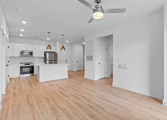 A modern kitchen with a wooden floor and white walls.