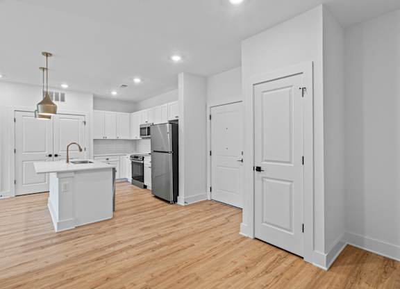 A kitchen with white cabinets and a white island.