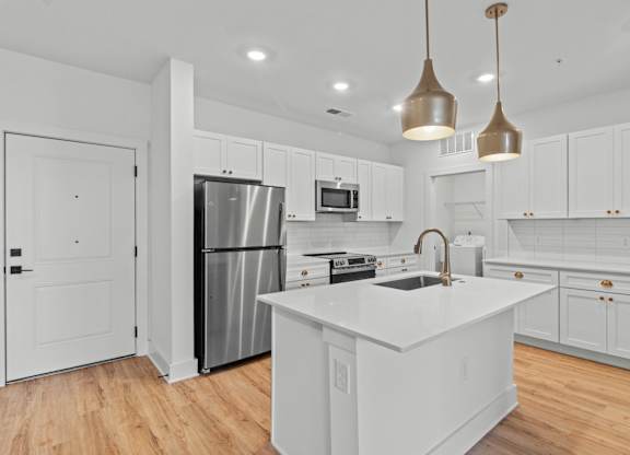 A modern kitchen with white cabinets and a central island.