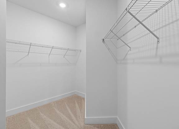 Empty room with a carpeted staircase and a metal rack.