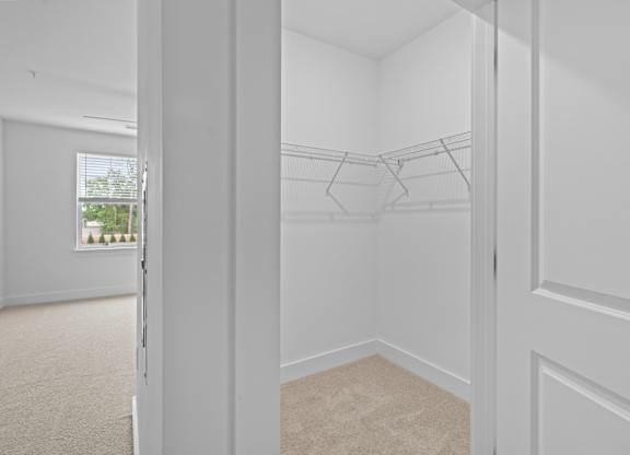 A white room with a carpeted floor and a white door.
