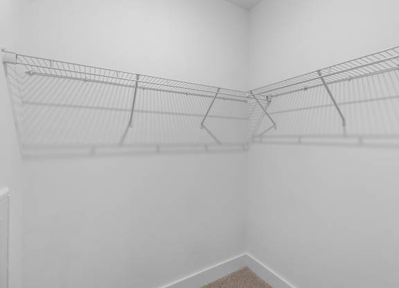 A white wall with a wire shelf attached to it.