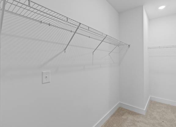 Empty room with a wire shelving unit and a carpeted floor.