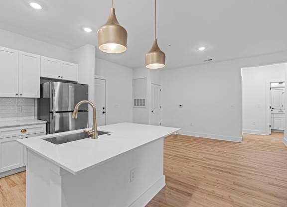 A modern kitchen with a white island and stainless steel appliances.