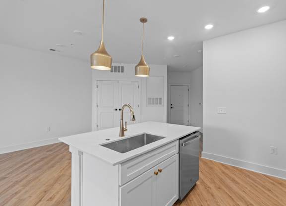 A kitchen with a white countertop and a sink.