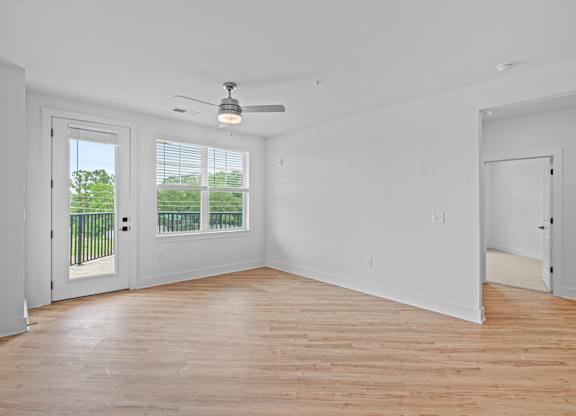 A room with a ceiling fan and a sliding glass door.
