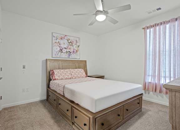 Ovata at Reedy Creek bedroom with ceiling fan and carpet.
