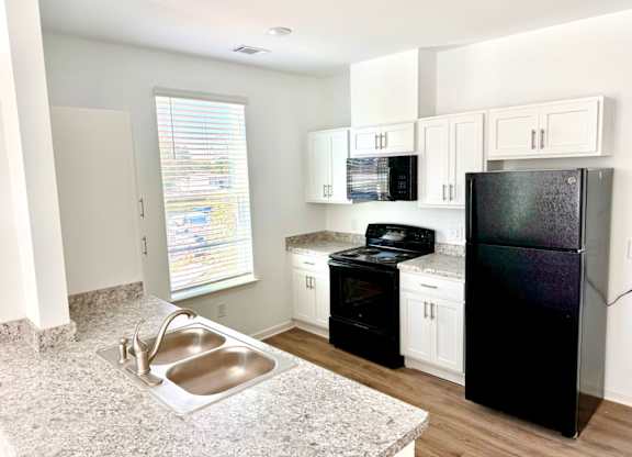 Ovata at Reedy Creek Kitchen with oven, range, microwave, refrigerator, granite countertop and stainless steel sink