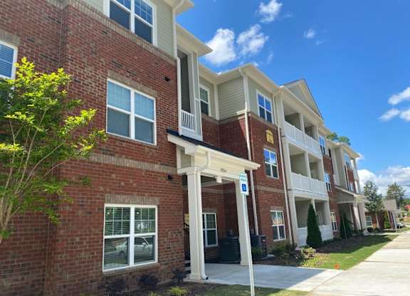 A row of townhouses with a blue sign in front.