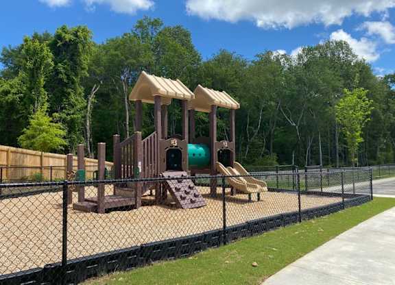 A playground with a slide and a wooden structure.