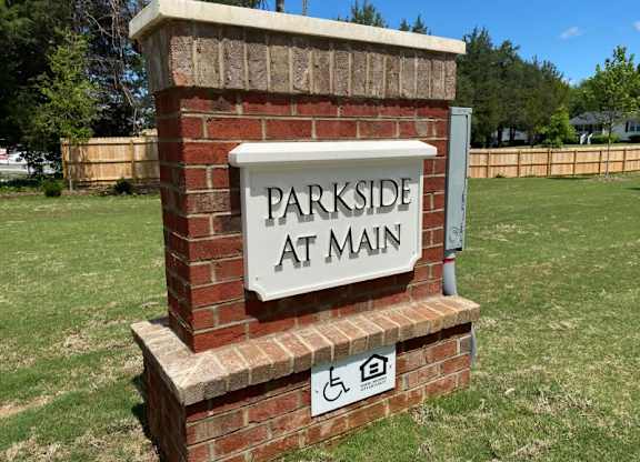 A brick pillar with a sign that says Parkside at Main.