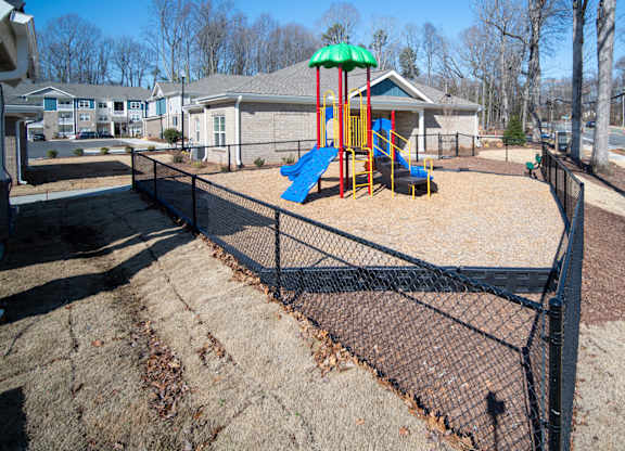 A playground with a blue slide and a green canopy.