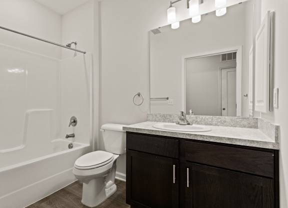A white bathroom with a toilet, sink, and bathtub.