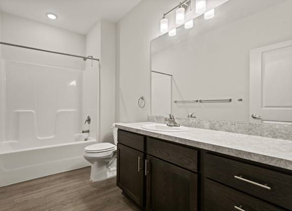 A white bathroom with a toilet, sink, and bathtub.