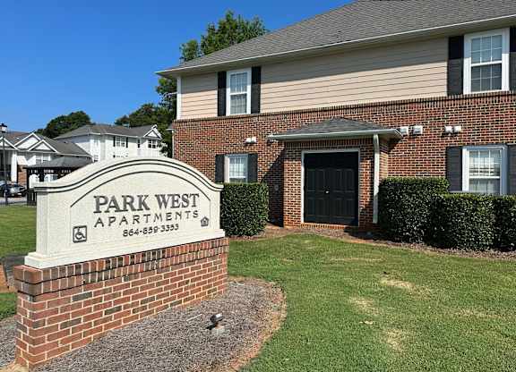 a park west apartments sign in front of a brick building