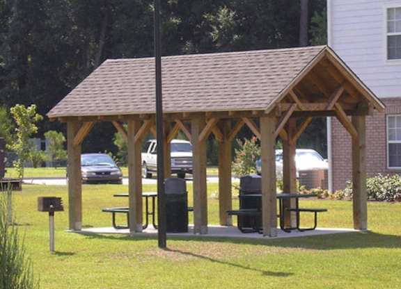 a man sitting on a picnic table in a pavilion