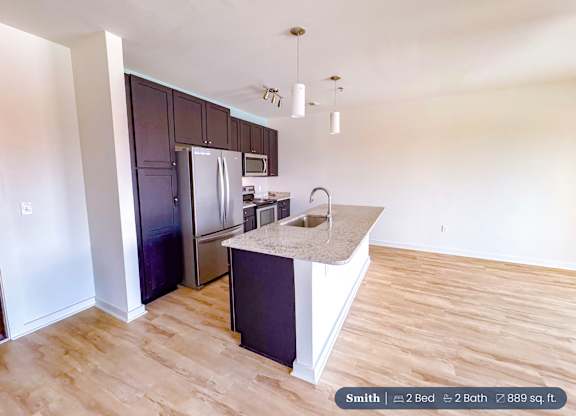 A kitchen with a sink and a refrigerator.