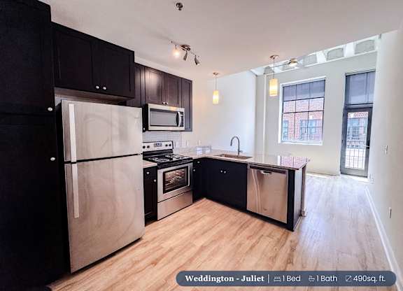 A kitchen with black cabinets and stainless steel appliances.