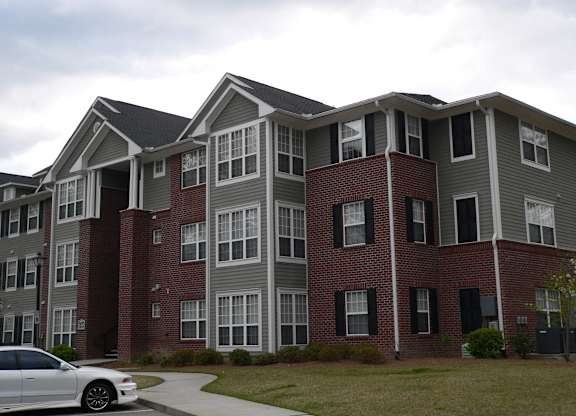 an apartment building with a car parked in front of it