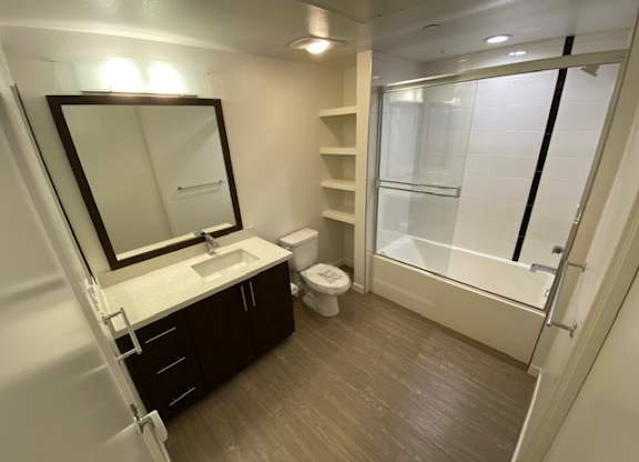 Bathroom with a toilet, sink, mirror, and shower/bathtub.