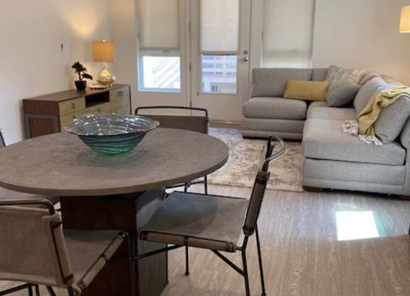 Modern living room and dining area with a table, chairs and sofa.