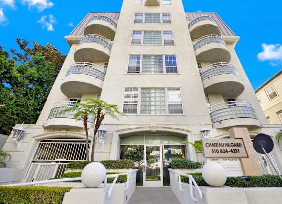 Entrace view of apartment building with a sign that reads Chateau Hilgard 310 824-4231.