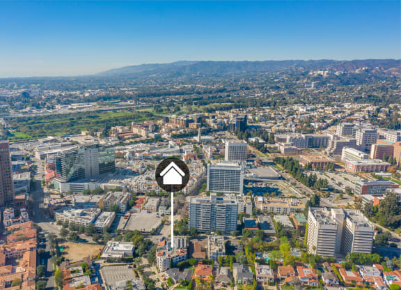 Aerial view of buildings and homes with property identification marker