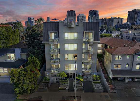 Exterior aerial view of apartment building at dusk.