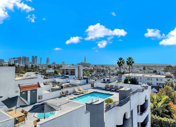 A rooftop pool area with a view of the city skyline at Midvale Court, Los Angeles