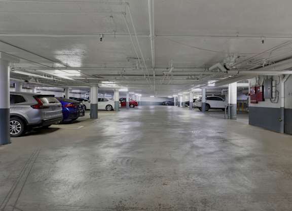 A spacious parking garage with multiple cars parked.