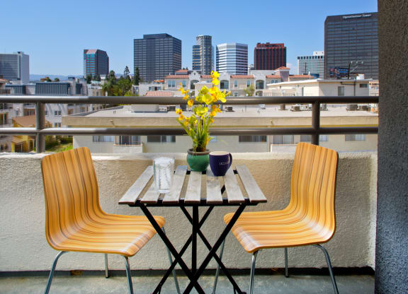 Apartment balcony with a cafe table and chairs with city views. at Midvale Court, California