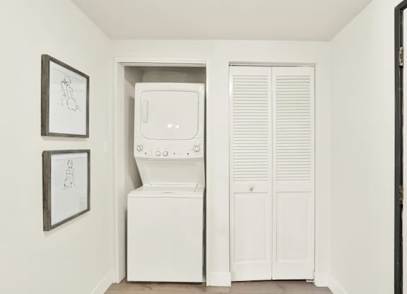A white washing machine and dryer in a small laundry room at Twelve One Ten Rochester, Los Angeles, CA