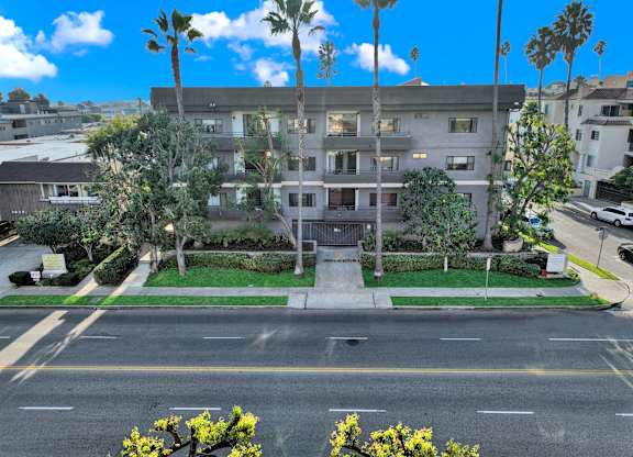 A building with a green lawn in front and a street in front of it at Twelve One Ten Rochester, California