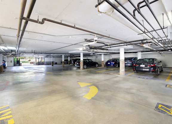 A parking garage with several cars parked and a yellow arrow on the ground at Twelve One Ten Rochester, Los Angeles