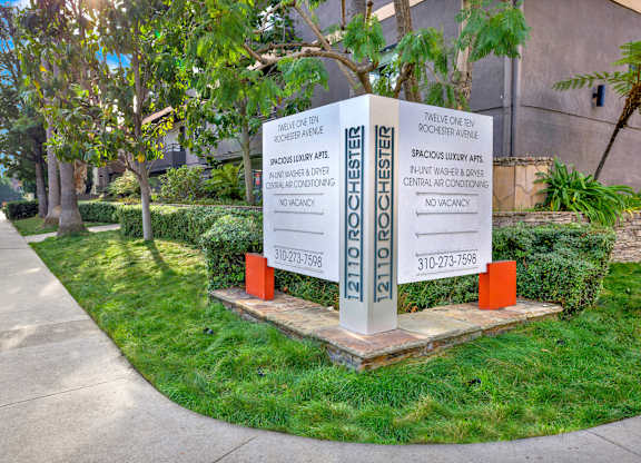 A sign in front of a building advertises a spacious luxury apartment at Twelve One Ten Rochester, Los Angeles, 90025