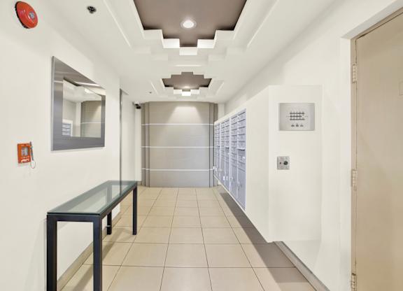 A long hallway with a glass table and a mirror on the wall at Peach Tree Court, California 90024