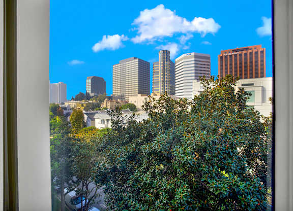 A cityscape with buildings and trees in the foreground at Peach Tree Court, California 90024