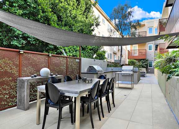 A patio with a table and chairs under a shade sail at The Urbanpolitan, Los Angeles, 90036