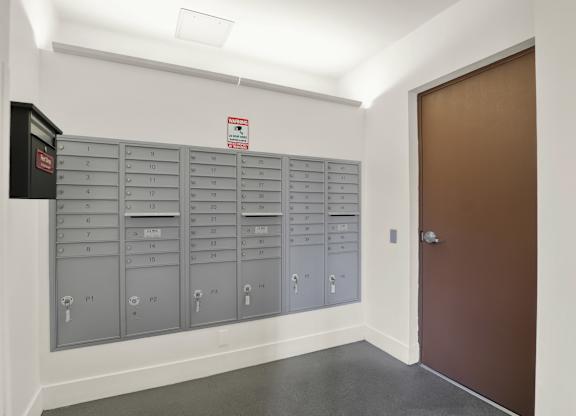 A row of mailboxes are lined up against a wall at The Urbanpolitan, Los Angeles, California