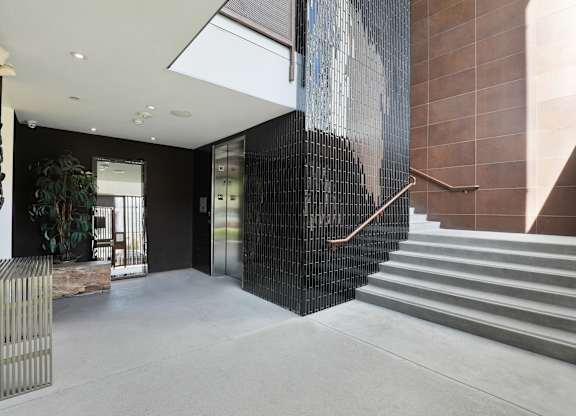 A staircase with a metal railing and a wall with a picture of a man on it at The Urbanpolitan, California