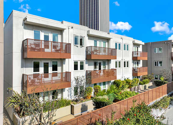 A row of modern apartment buildings with balconies and plants in front at The Urbanpolitan, California 90036