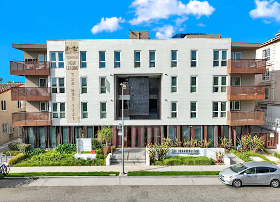 A modern apartment building with a sign that says at The Urbanpolitan, California