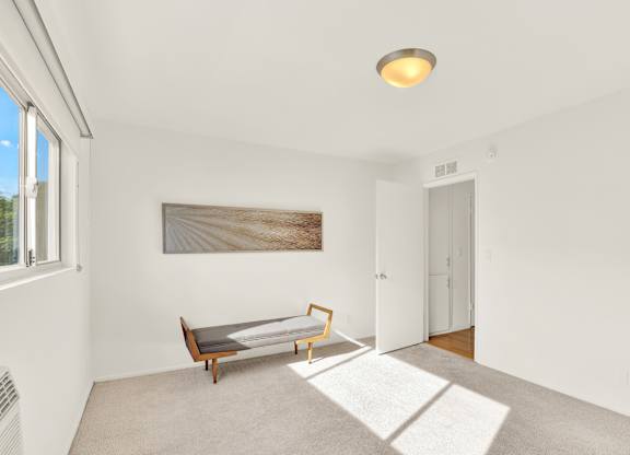 A room with a bench and a painting on the wall at Wooster Encore Apartments, Los Angeles, CA 90035