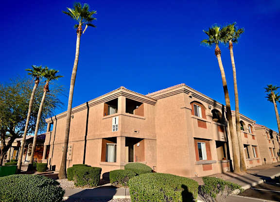 A building with palm trees in front of it.