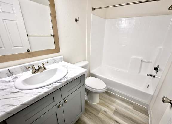 A bathroom with a marble countertop and a white toilet.