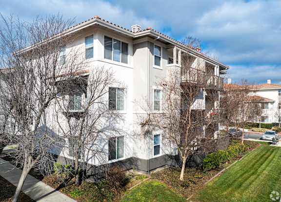 A large white building with a red roof and a tree in front at Cornerstone at Gale Ranch Apartments, San Ramon, CA, 94582