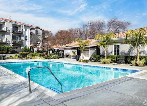 A swimming pool surrounded by a concrete patio and apartment buildings at Cornerstone at Gale Ranch Apartments, San Ramon, CA
